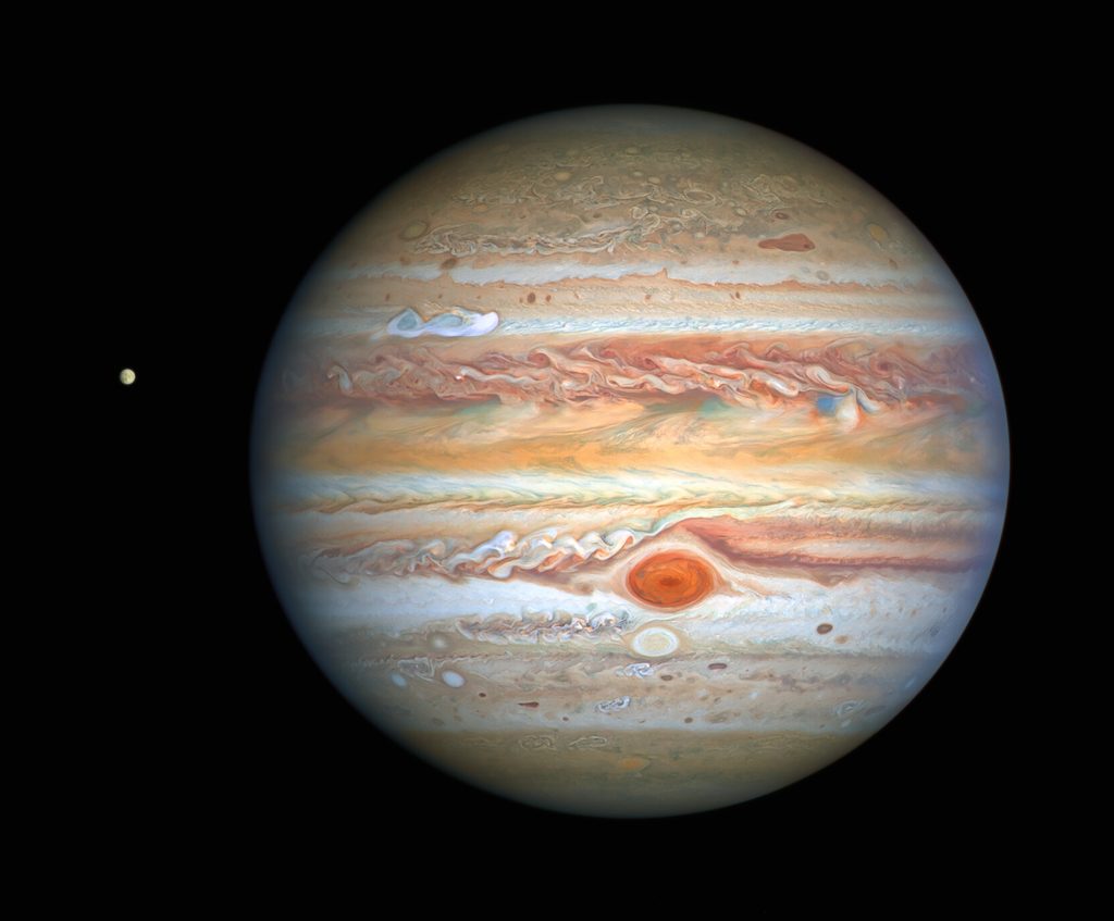 Immagine che mostra una ripresa di Giove e del satellite Io realizzata dal Telescopio Spaziale Hubble